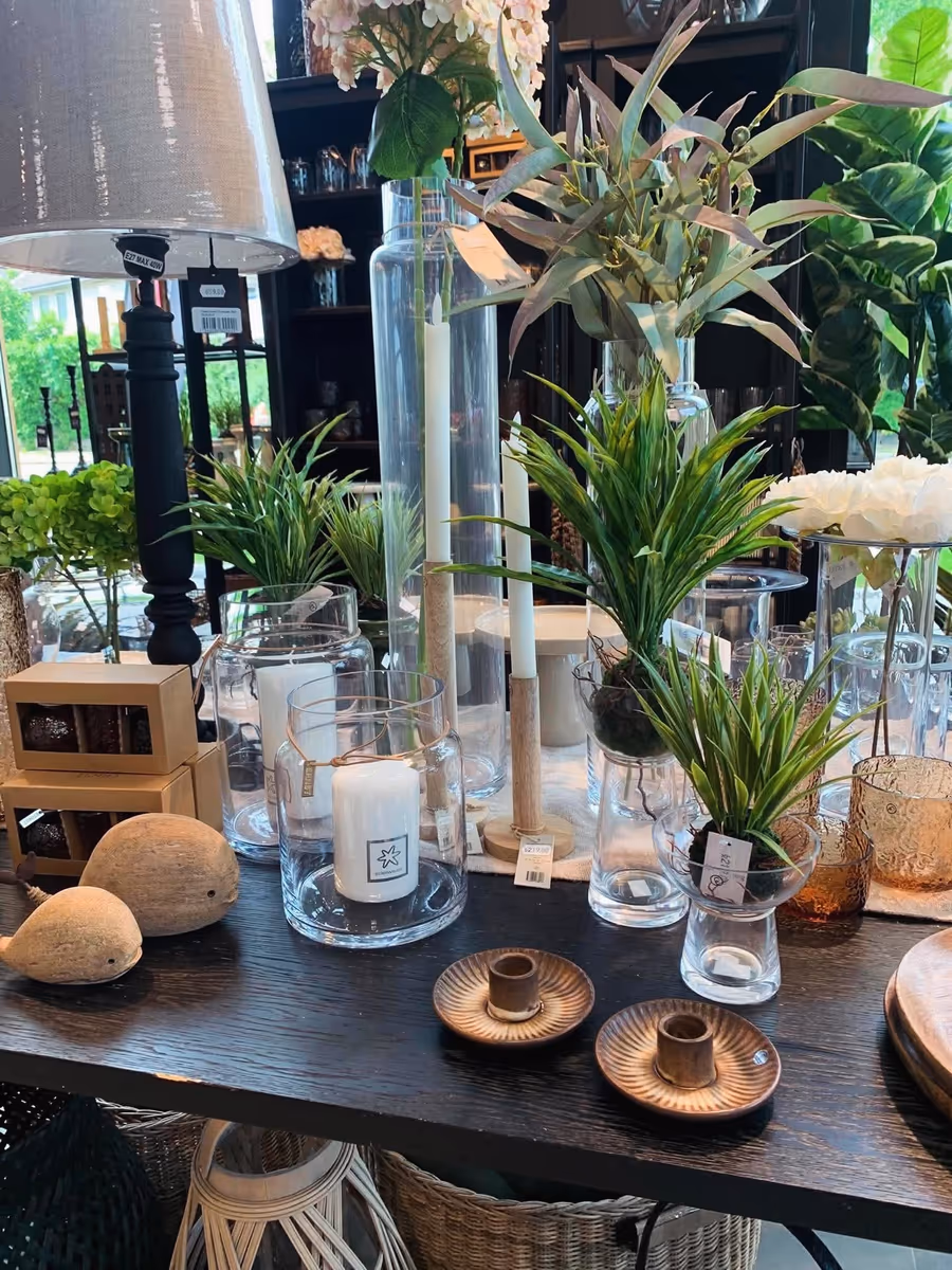 Glassvaser, planter og lys på et bord