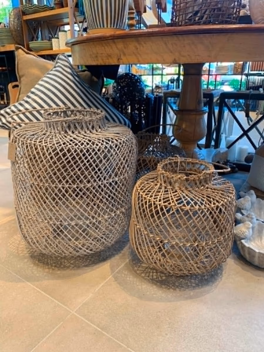 Store flettede kurv-lykter i naturmateriale på gulvet i butikken