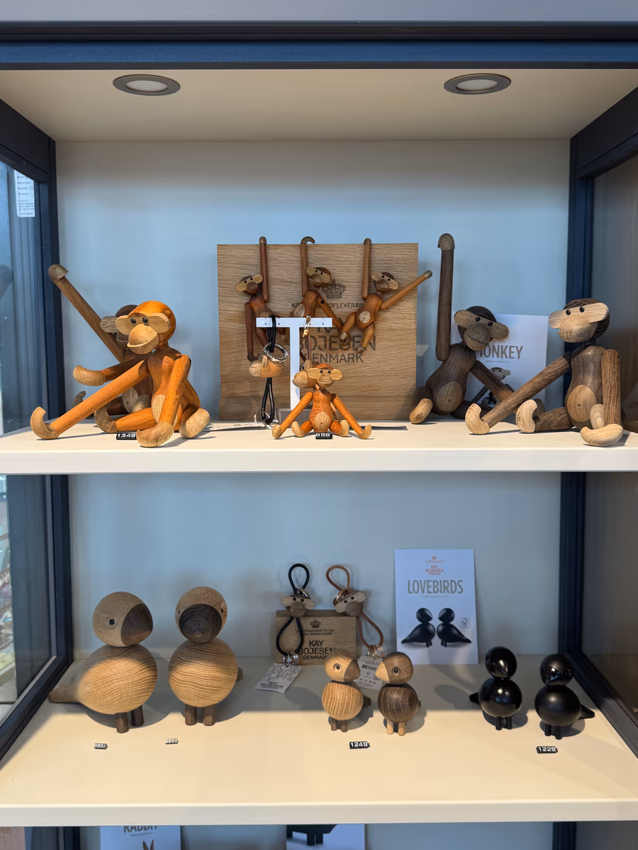 Vitrine med Kay Bojesen-figurer i tre — aper, songbirds og lovebirds