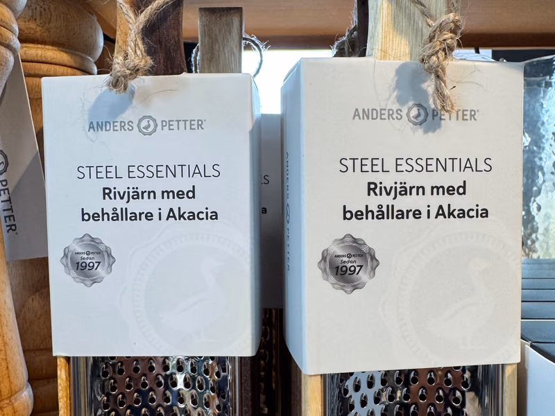 To rivjern i stål med holder i akasie fra Anders Petter Steel Essentials, i lys og mørk tre, på hylla hos Gressvik Gullsmed