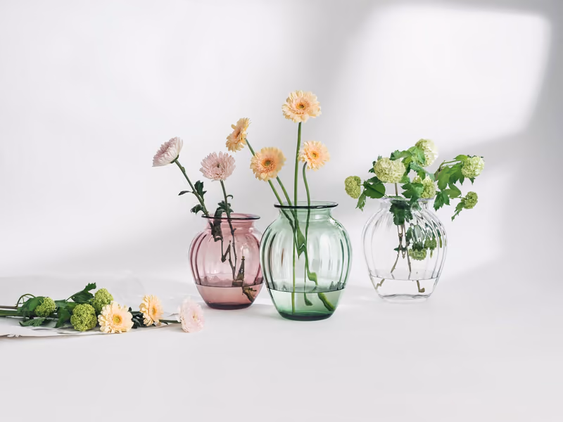 Tre Emily-vaser fra Hadeland Glassverk i rosa, grønt og klart glass med blomster i
