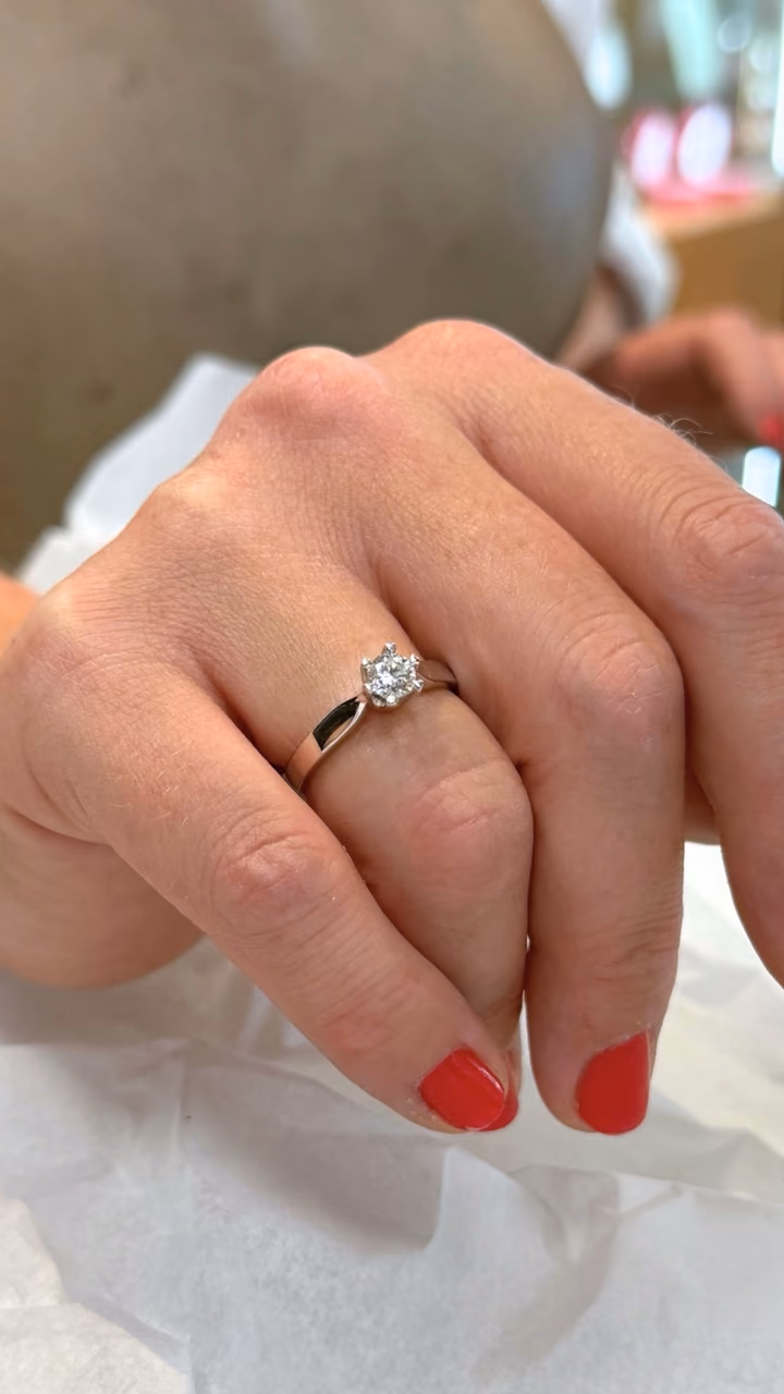 Enstensring fra HeleneV med én diamant i seks klør, på en hånd som hviler på hvitt silkepapir