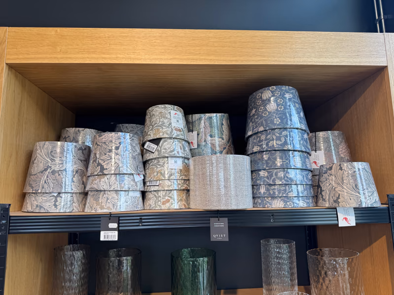 Hylle med lampeskjermer fra Qvist Studio i William Morris-mønstre i beige, grønt og blått, stablet i interiøravdelingen hos Gressvik Gullsmed