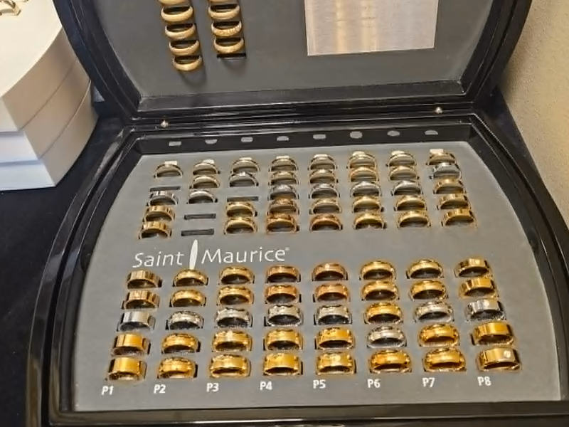 Åpen prøveringkoffert fra Saint Maurice med rader av gifteringer i gult og hvitt gull